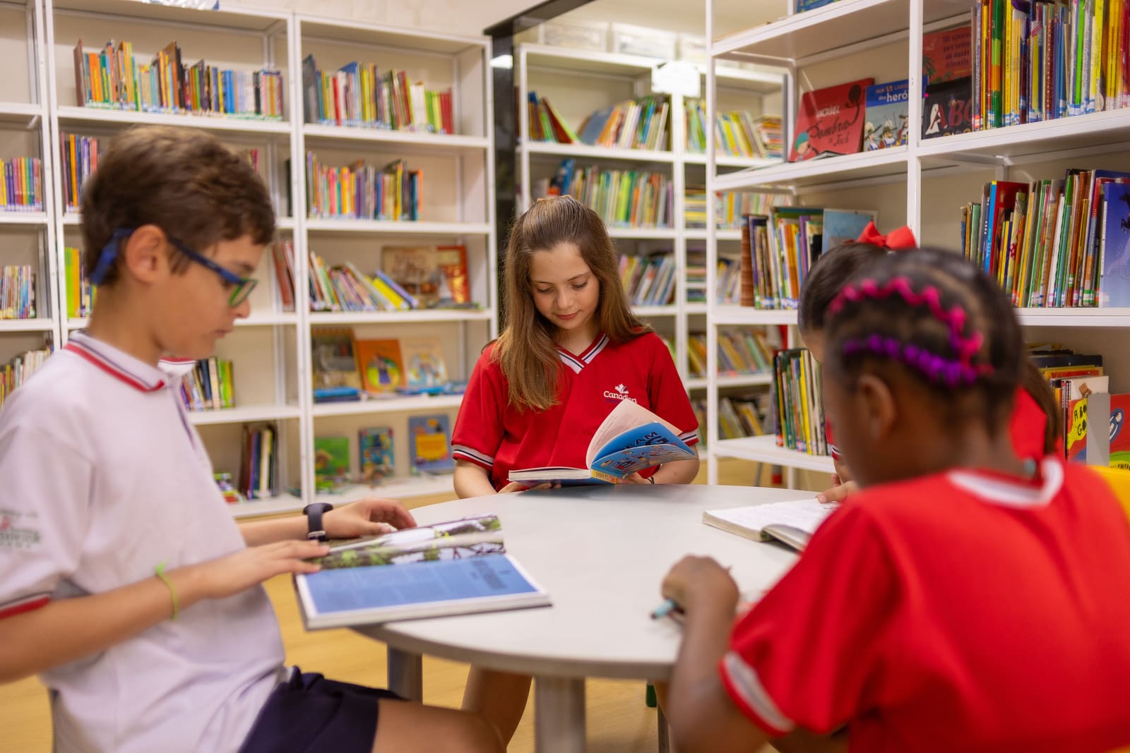 Alunos lendo e pesquisando na biblioteca da Canadian School de Niterói