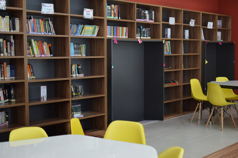 Biblioteca da Canadian School de Niterói com estantes de livros